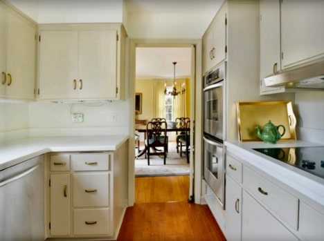 outdated galley kitchen with white cabinets from 1960's