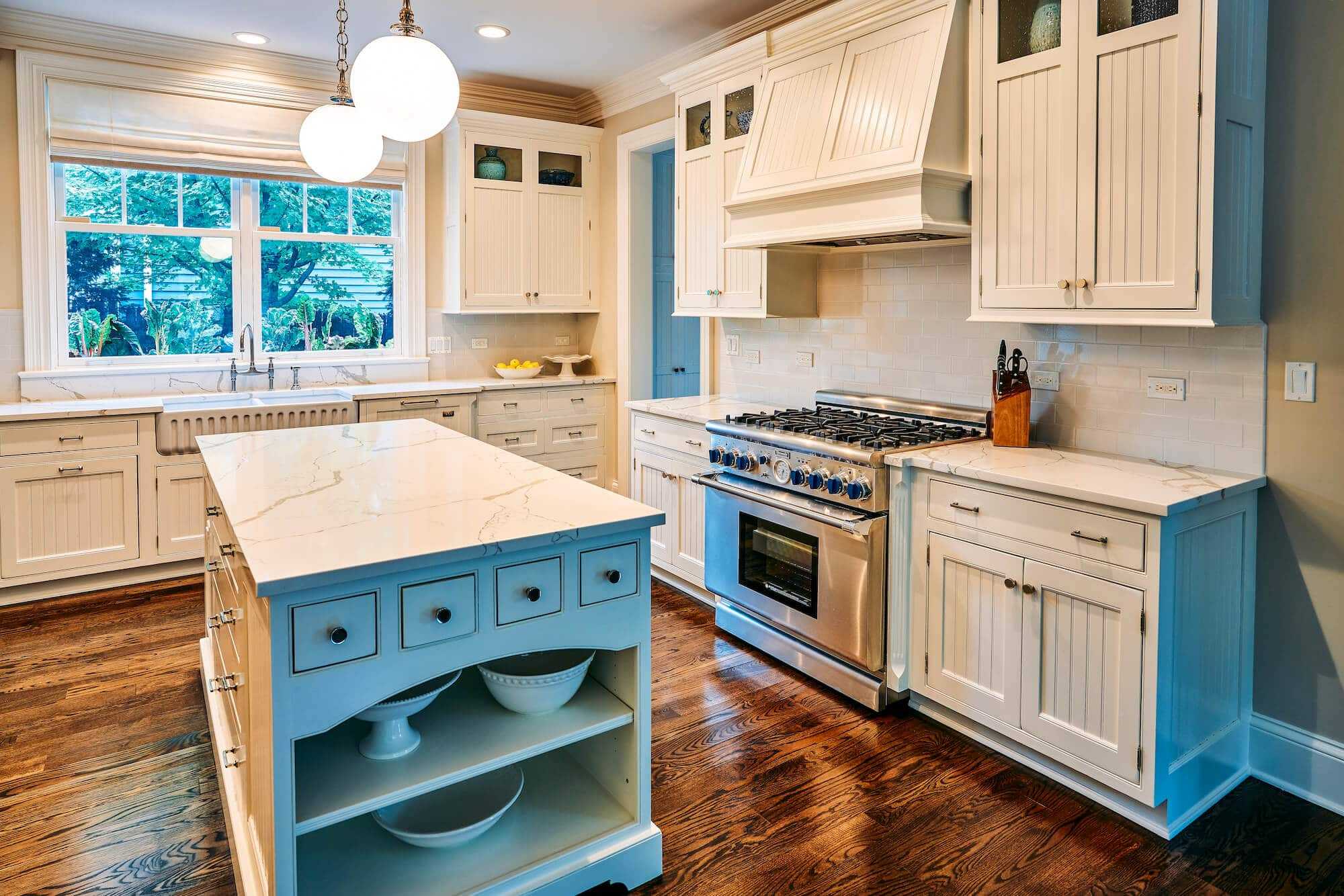 all white kitchen with white cabinets, white tile backsplash and white quartz countertops