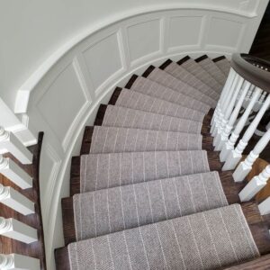 Curved stair case with modern gray wool herringbone stair runner with stripes.png