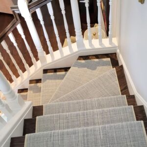 Curved stairs with textured stair runner in neutral pattern with light binding.png