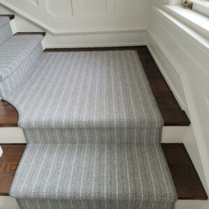 Light grey stair runner with stripes and small landing