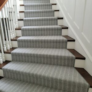 Striped grey stair runner with elongated stairs at base.png