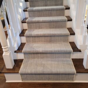 Textured neutral stair runner with Hollywood installation.png